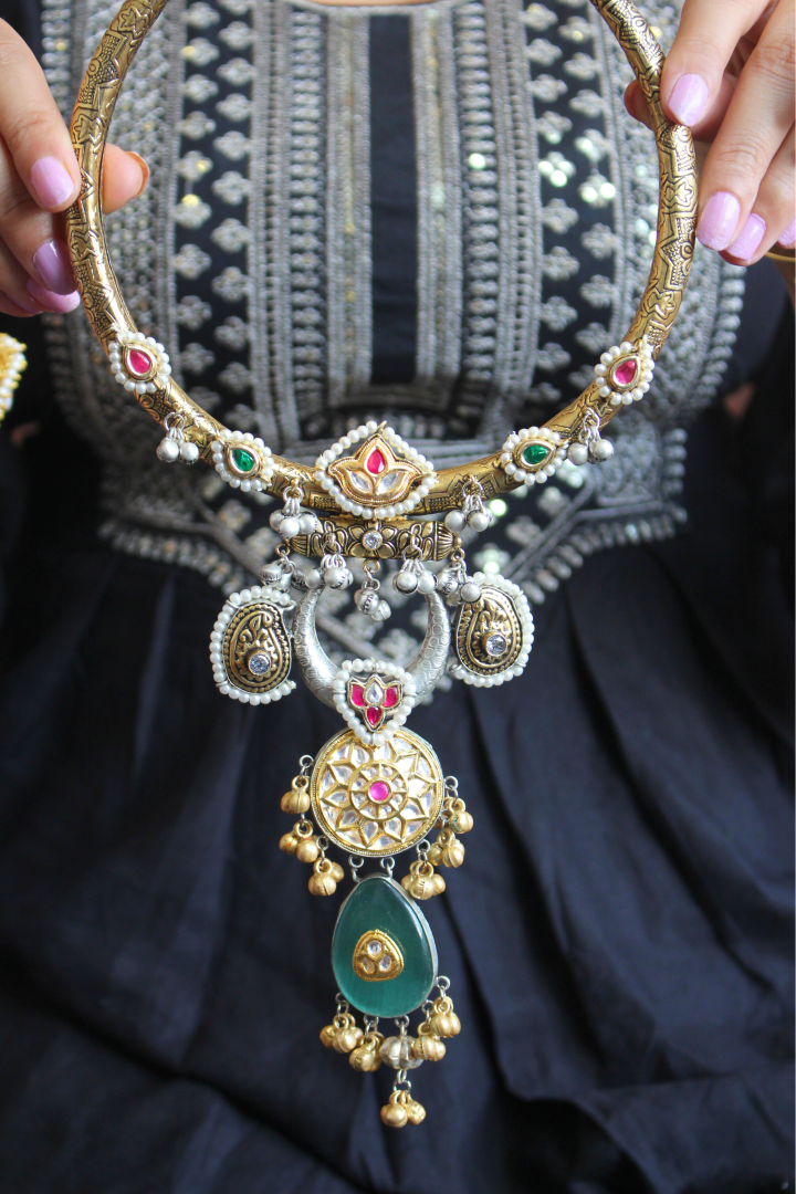 Hasli necklace with intricate designs held by a person