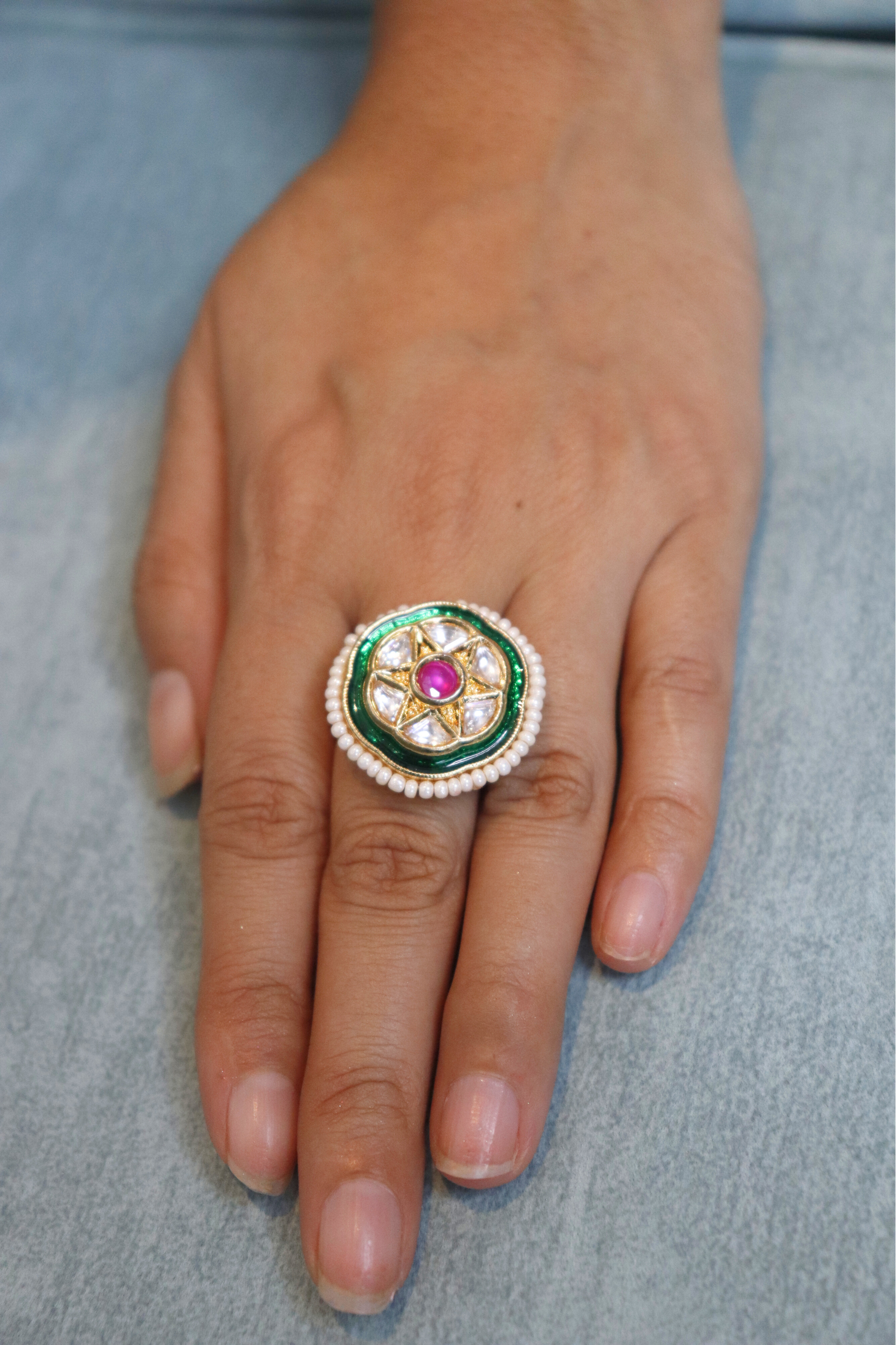 Close-up of a hand wearing a decorative ring with a gemstone