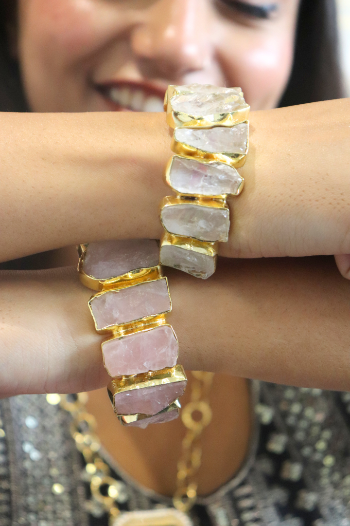 Close-up of a person wearing a gold and stone bracelet.
