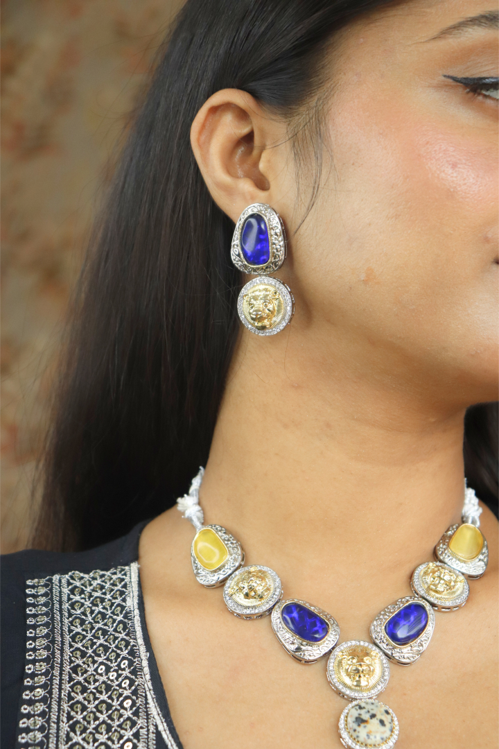 Close-up of a women wearing a silver necklace with colorful stones and matching earrings.