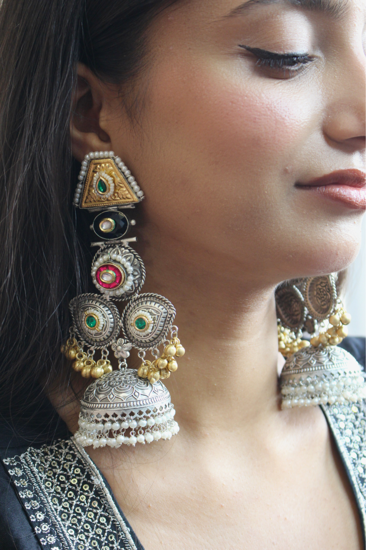 Close-up of a woman wearing ornate earrings with intricate designs.