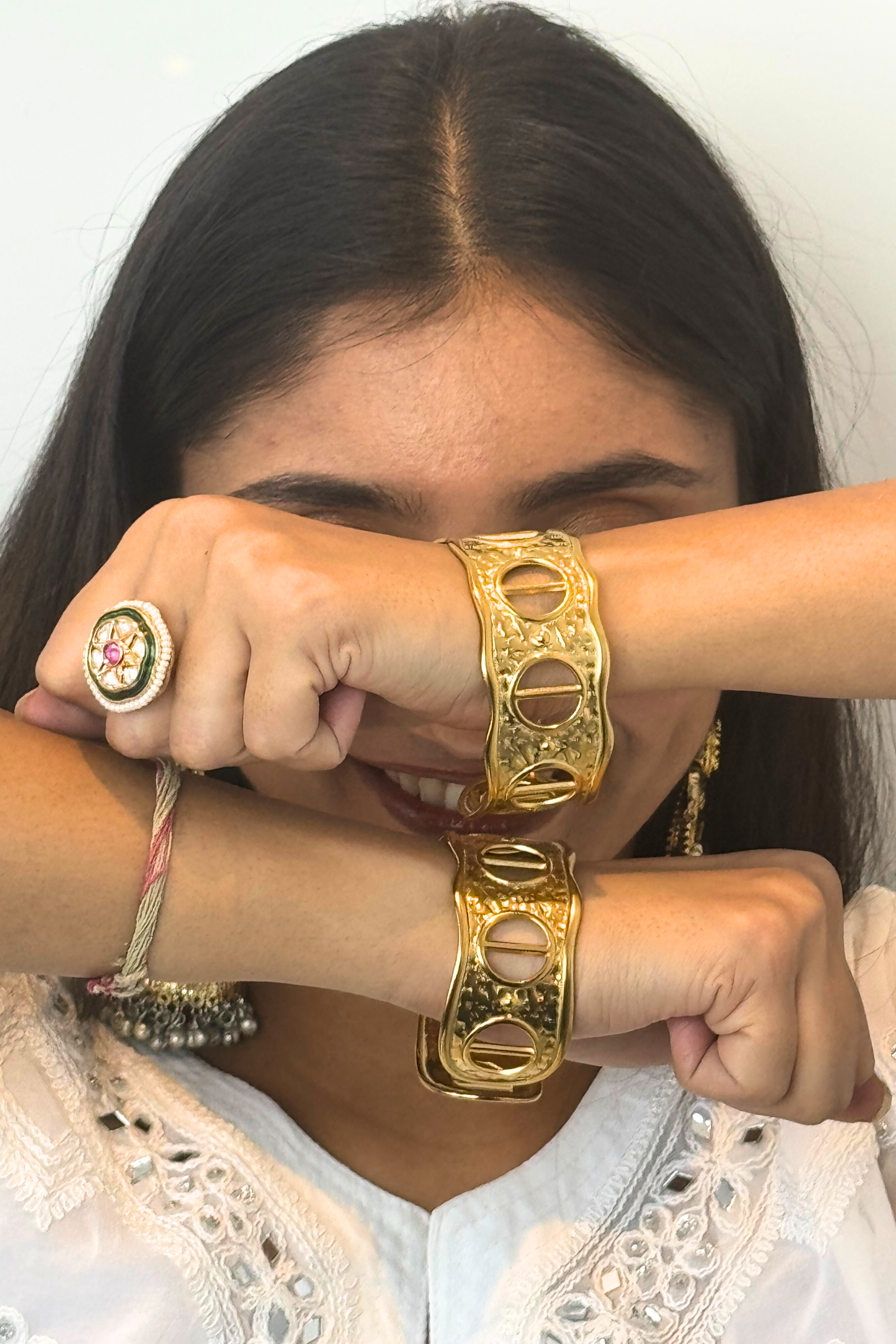 Person wearing gold jewelry including a ring and bracelet